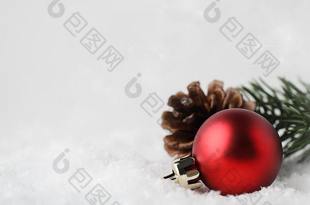 在右下角的白色假雪中依偎着一个圣诞边框和背景，红色装饰物，杉木圆锥体和绿色树枝。b中闪烁的星星
