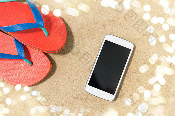 沙滩上的智能手机和人字拖
