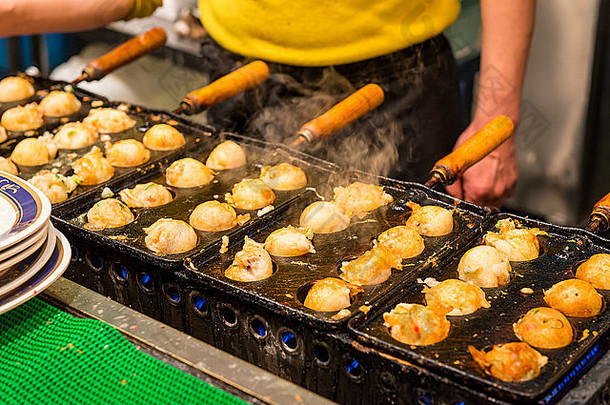 Takoyaki在日本大阪的一个街边小吃摊上被烤。