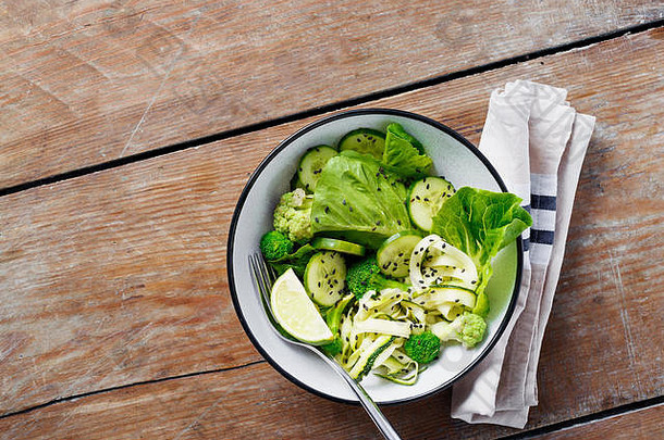健康的素食者沙拉绿色蔬菜碗木表格西兰花罗马沙拉西葫芦石灰黄瓜前视图