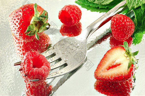 新鲜冷冻的覆盆子和草莓，<strong>薄荷色</strong>，反光背景，浅景深