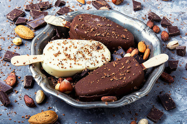 盛有巧克力馅和坚果的夏季冰淇淋的托盘