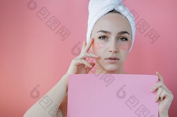 粉红色背景上有眼罩的美女肖像。戴着眼罩的美女脸。皮肤护理、化妆品产品概念与副本