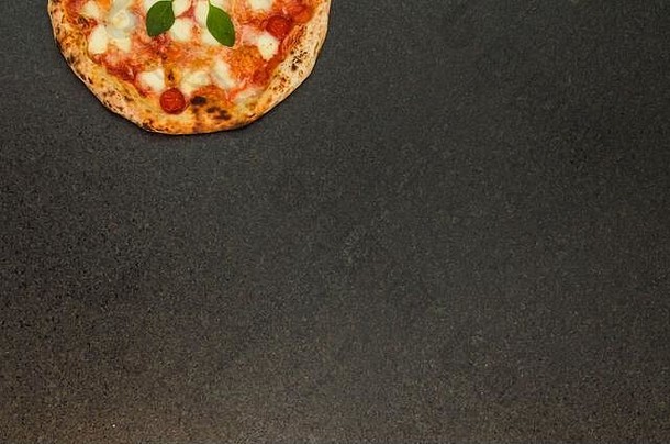 烹饪主题的绝佳背景，黑花岗岩背景上的玛格丽特风味手工比萨饼，不同成分。