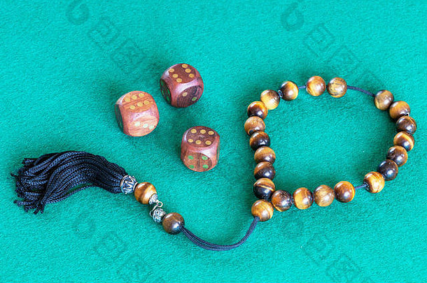 担心珠（komboloi）和三个六点木骰子放在绿色的baize桌上