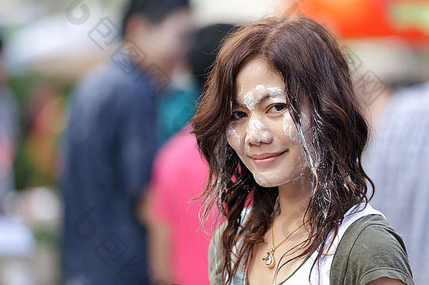 泰国泼水节期间，美丽的亚洲女人脸上沾满了湿粉