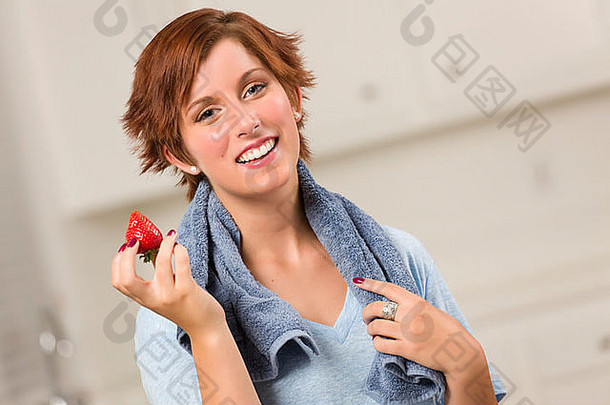 <strong>漂亮</strong>的红发女人拿着毛巾在<strong>厨房</strong>里拿着草莓。