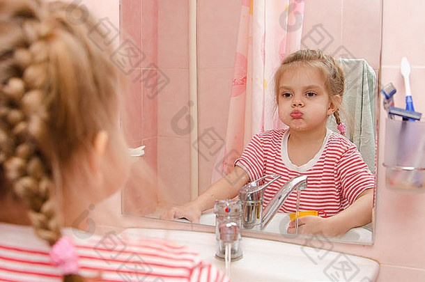 四岁的女孩冲洗牙齿刷牙女孩镜子浴室
