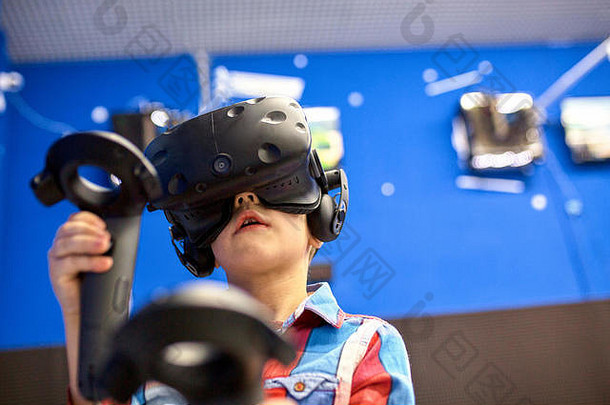 现代技术、游戏和人的概念-戴着虚拟现实耳机或3d眼镜的男孩在游戏中心玩视频游戏