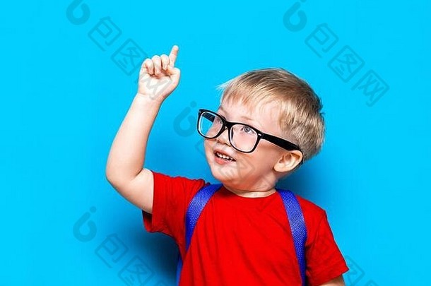 回到学校一年级<strong>初中</strong>生活方式。穿红色t恤的小男孩。摄影棚特写照片：戴眼镜的微笑男孩，带着书包和相机