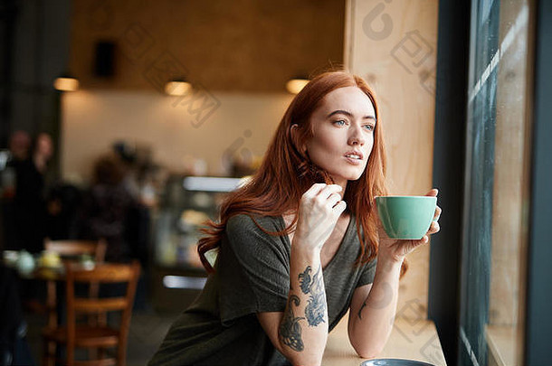 红色的头女孩手臂纹身坐着咖啡馆窗口利物浦