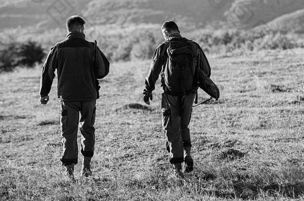 猎人、朋友、猎场看守人在山间漫步。猎人在自然环境中。猎人朋友享受休闲。与伴侣一起狩猎可以提供更大的安全感，通常是乐趣和回报。