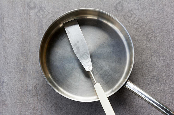 清洁空不锈钢钢煎锅抹刀开销视图灰色的背景特写镜头前视图