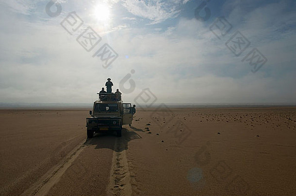 沙漠旅行中乘坐4X4的游客剪影