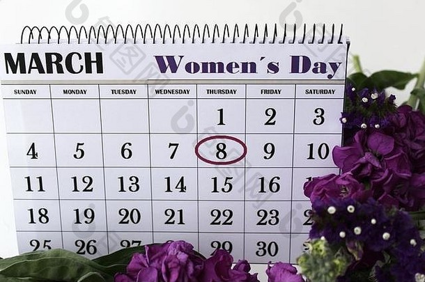 紫色和白色的百合花和水芹花以及在白色背景上标记有妇女节的日历。