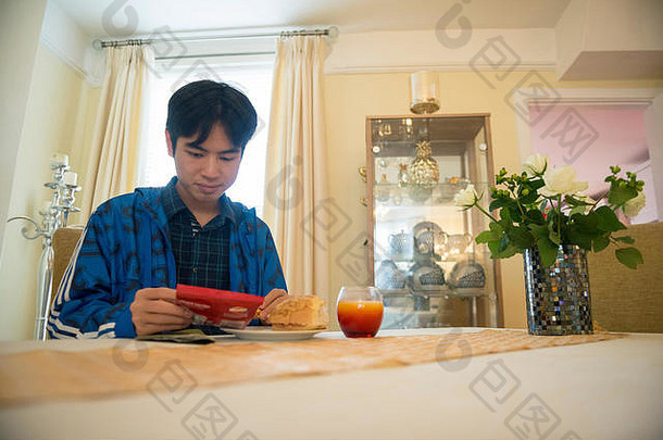 一名年轻的亚洲<strong>留学</strong>生在寄宿家庭的厨房里准备午餐