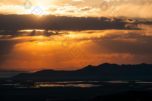 大赛尔湖和犹他州山脉上空云层后的日落