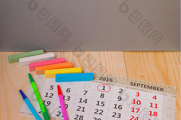 回到学校，日历，木制背景上的彩色粉笔。