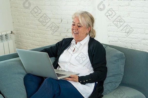 2019冠状病毒疾病。快乐的老太太在家里用笔记本电脑给家人打视频电话，或与远程朋友在线聊天。冠状病毒锁定