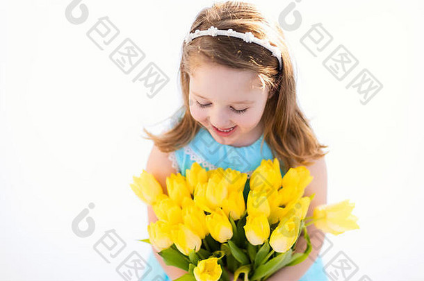 可爱的女孩蓝色的衣服持有郁金香花花束生日聚会，派对春天复活节装饰孩子黄色的花孩子撒