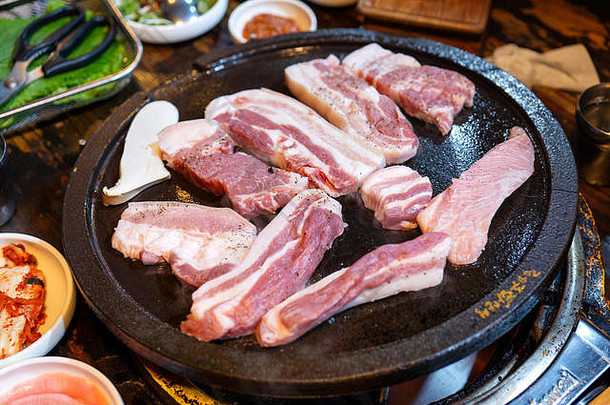 韩国餐厅的煎黑猪肉餐，新鲜美味的韩国美食，铁板上放着生菜，特写，空间，生活方式