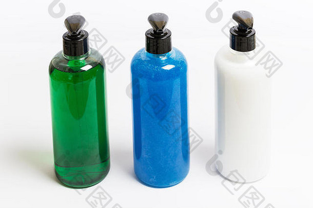 将三台不同颜色的皂液分配器置于白色背景上