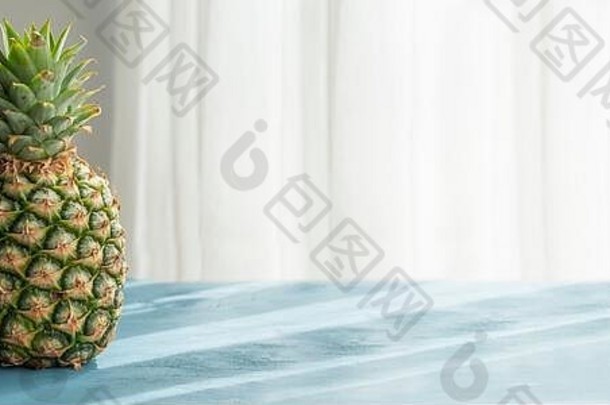 新鲜的有机菠萝，蓝色木材表面，明亮的自然sın光。