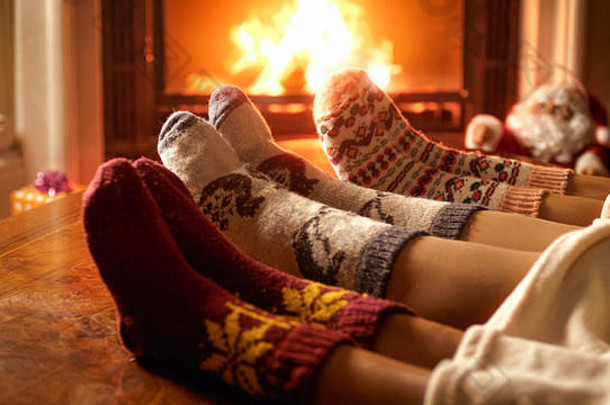 一家人穿着羊毛袜子躺在壁炉旁的特写照片