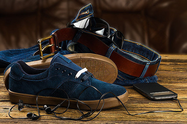 黑暗蓝色的男人的鞋子牛仔裤智能手机配件木背景