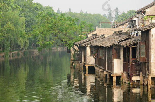 中国浙江省桐乡乌镇风景小镇东景水渠旁的木质风化建筑