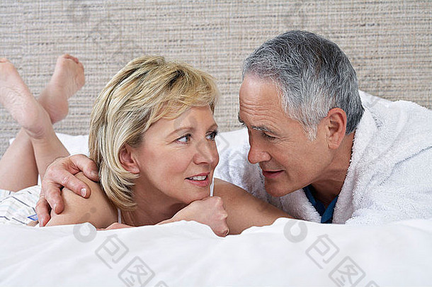 一对中年夫妇躺在床上聊天