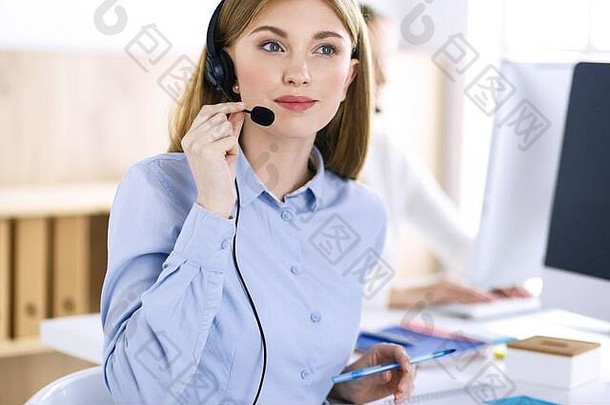呼叫中心接线员工作时的肖像。一群人戴着耳机随时准备帮助客户。经营理念