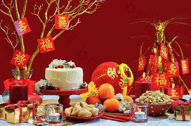 中国新年宴会桌以红色和金色为主题，配有食物和传统装饰。