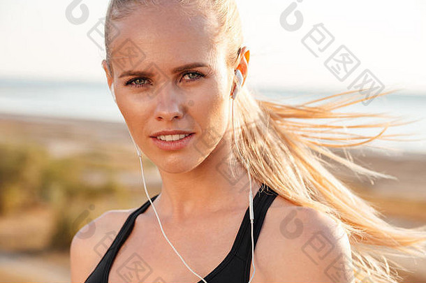 肖像运动金发女郎女人耳机在户外相机