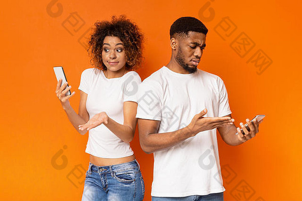 失望的黑人千禧一代男女看着智能手机