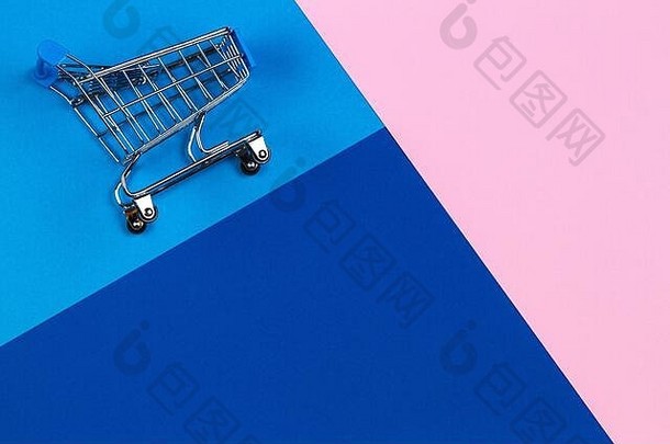 粉色、浅蓝色和海军蓝背景的迷你购物车。网上购物、购买、销售、折扣概念
