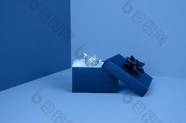 闪亮背景上的蓝色礼品盒，饰有纹理蝴蝶结。通常用于生日、周年纪念礼物、礼品卡、明信片。