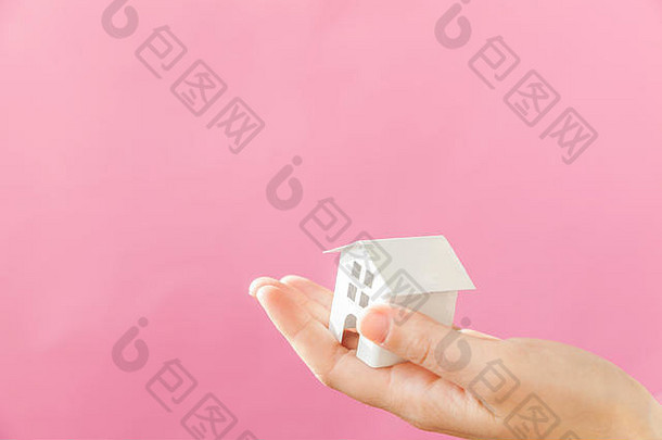 简单的设计女女人手持有微型白色玩具房子孤立的粉红色的柔和的色彩斑斓的时尚的背景抵押贷款财产保险梦想首页概念复制空间