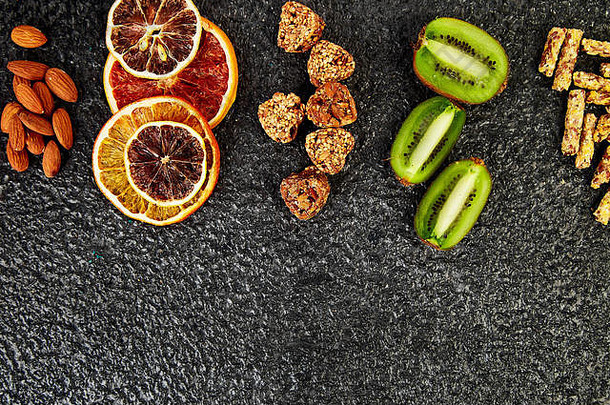 健康的零食各种燕麦格兰诺拉麦片酒吧大米瘸子帮杏仁猕猴桃干橙色黑色的背景混合分类前视图饮食食物谷蛋白