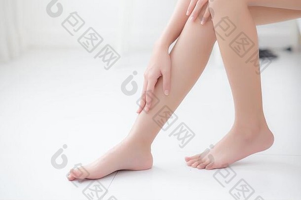 美丽的年轻的亚洲女人触摸皮肤腿光滑的奶油乳液水合作用光滑的女孩应用身体护理化妆品柔滑的