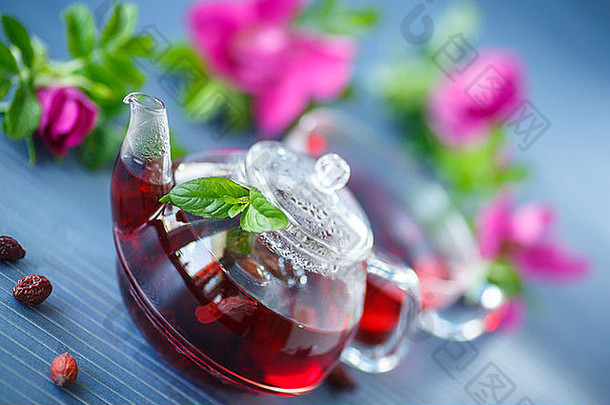 桌上的茶壶里有水果和鲜花的玫瑰果茶