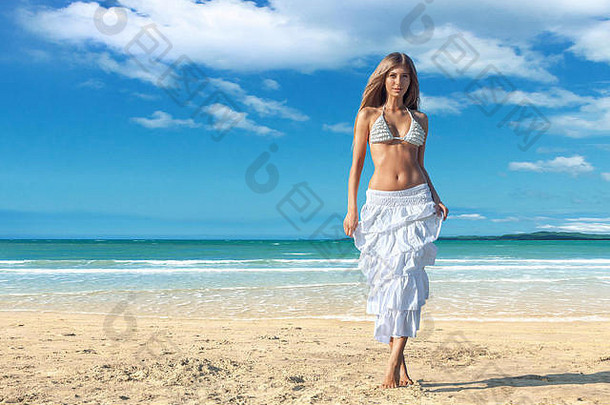 年轻时尚女郎在热带海滩摆姿势