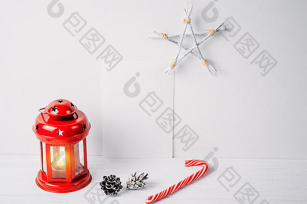 红色灯笼，带蜡烛、松果、星星和白色背景上的白色空床单。圣诞装饰