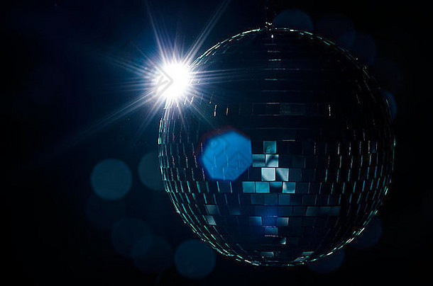 背景上有闪光和模糊灯光的迪斯科球。在派对传单上用作示例的夜生活图像。