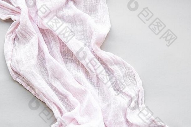 白色背景上折叠的粉红色围巾。平铺。