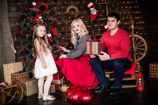 美丽的年轻的家庭红色的有趣的圣诞节假期坐着生活房间地板上很好地装饰圣诞节树