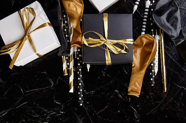 生日或派对配件，配有礼品盒、气球、金色、黑色和白色蜡烛。平面布置，俯视图