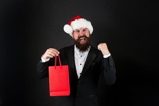 正好赶上节礼日。快乐的经理拿着纸袋，做着赢家的手势。留胡子的男人庆祝节礼日。新年。圣诞快乐。节礼日大减价。节礼日最想要的礼物，空间。