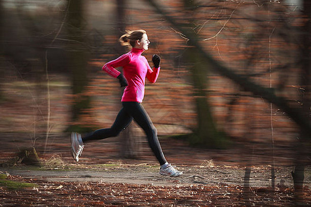 在寒冷的秋冬季<strong>节</strong>，一位年轻女子在城市公园里<strong>跑步</strong>