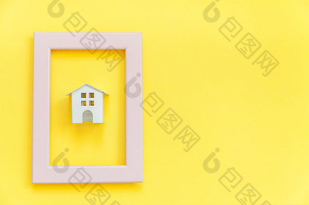 简单设计，粉色框架内的迷你白色玩具屋与彩色时尚黄色背景隔离。抵押财产保险梦想家园概念。平面俯视图空间